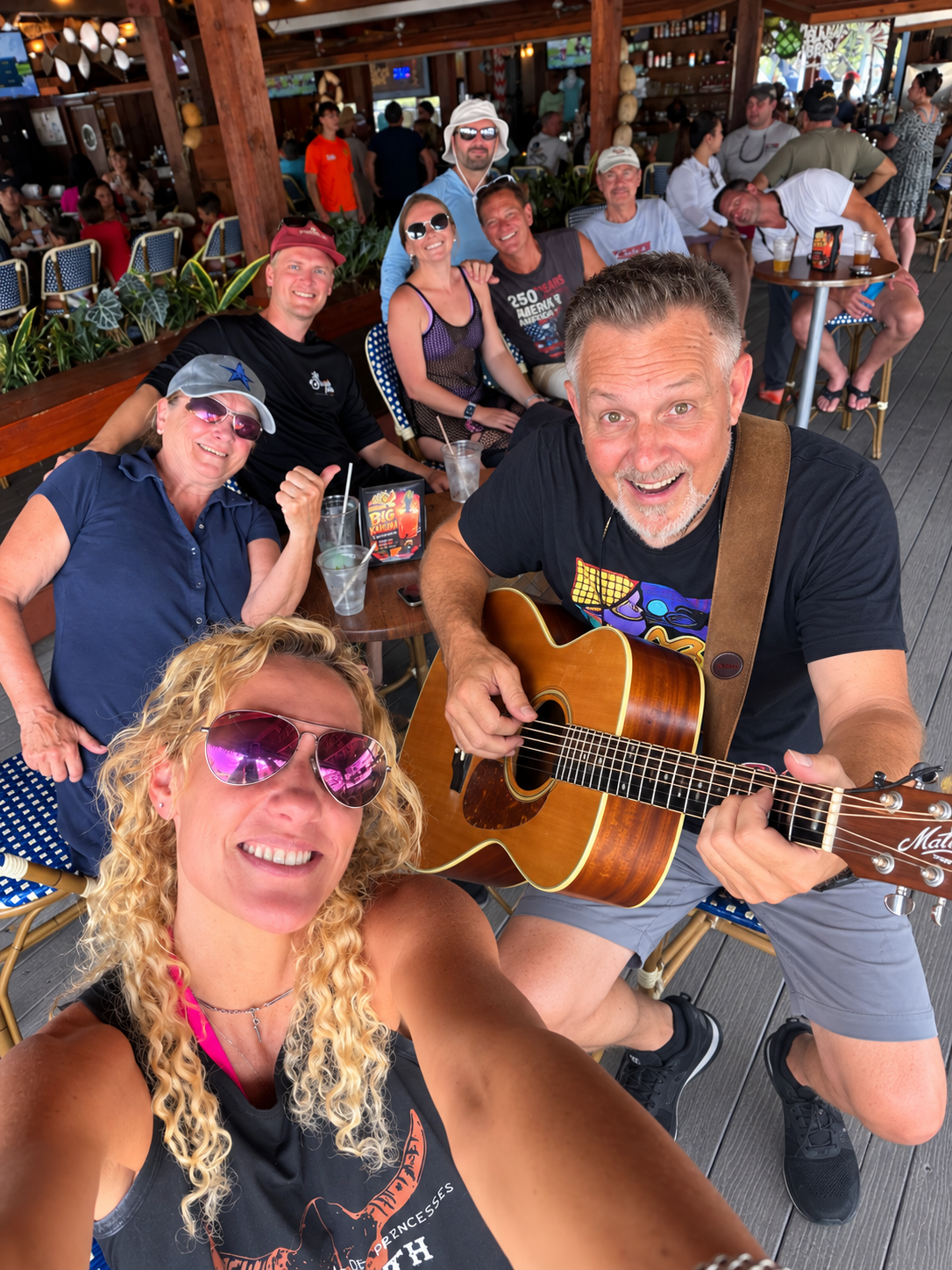 Friends gathered at the tiki bar enjoying Craig Gleason perform live
